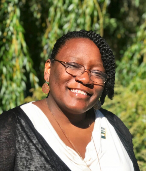 Headshot of Latoya Haynes-Thoby smiling and wearing glasses in front of trees.